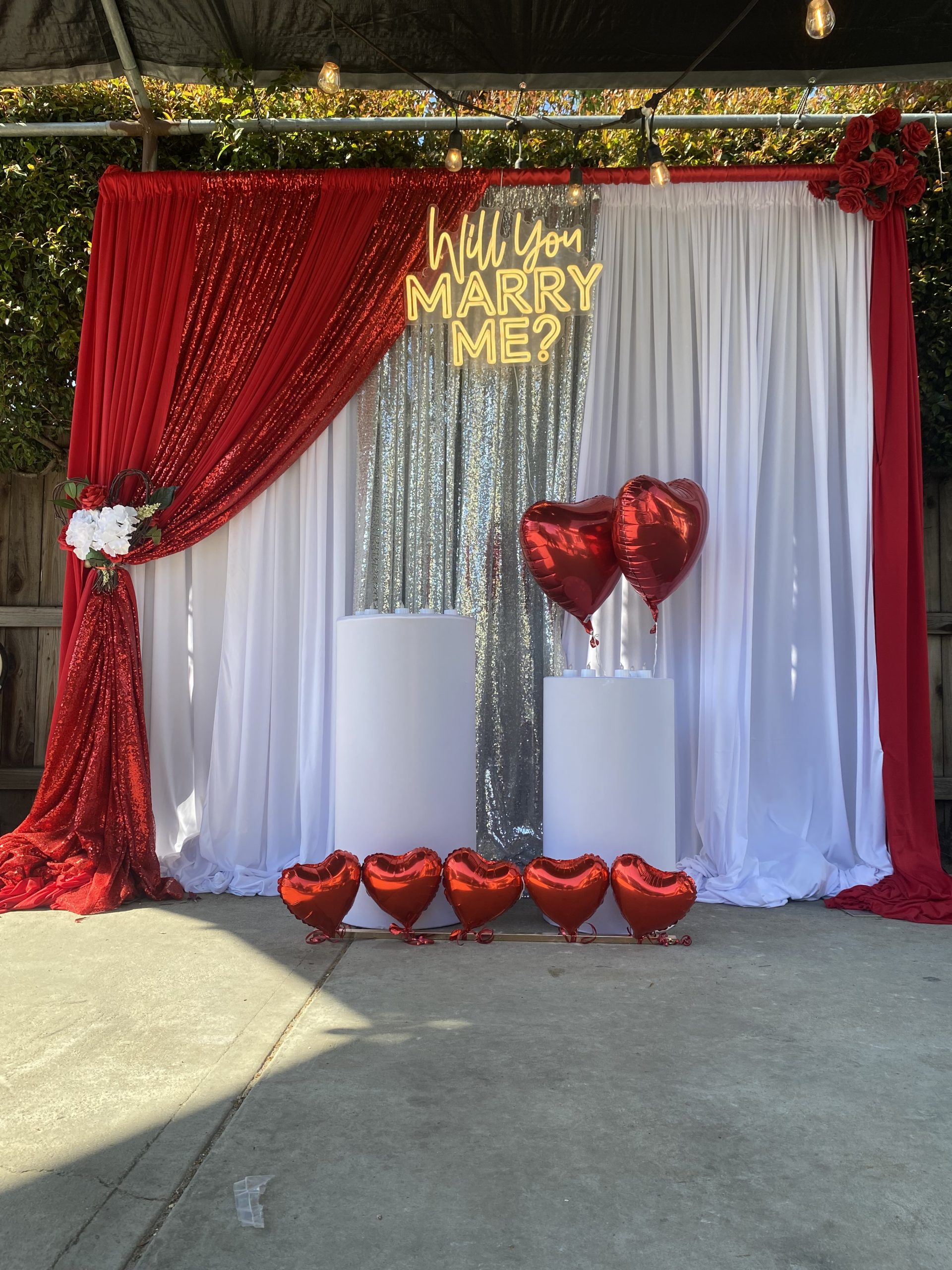 Red and white event backdrop with draping and decorative styling
