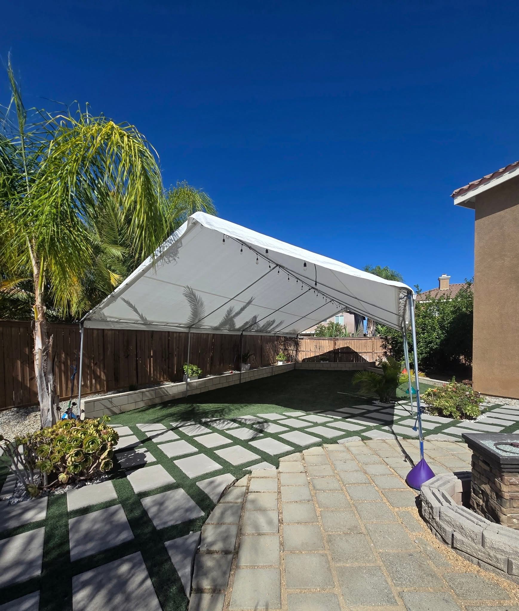 White residential tent rental installed in a backyard