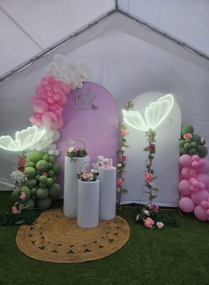 Pink and green decorated baby shower backdrop inside an event tent