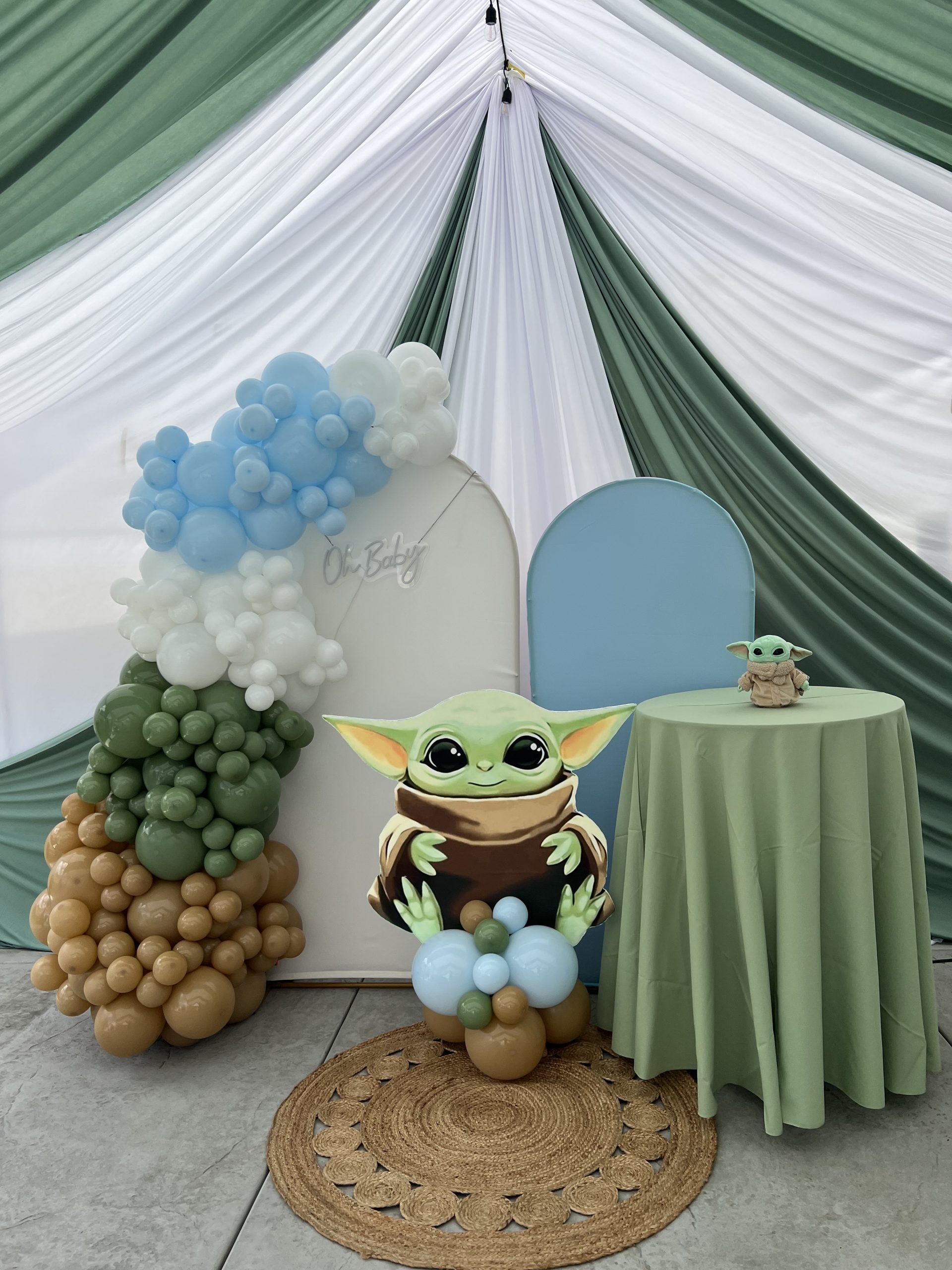 Event table with sage green linen inside a draped party tent